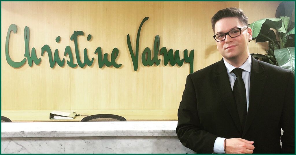 Gabriel is standing confidently in front of the Christine Valmy front desk.