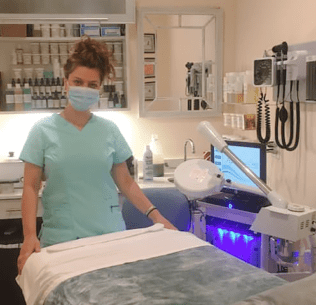 Esthetician standing in spa wearing a mask with products in the background