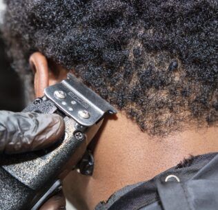 Barber cleaning up the back of their client's hairline