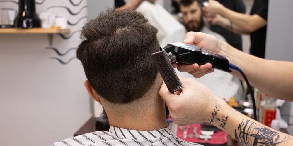 Barber shaving his male client's hair